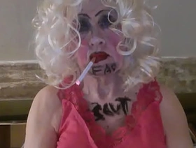 CD Sissy Sarah Millward knows her ID, as indicated by what's written on her face and chest - 'fag slut' -   as she smokes, wanks her clit, and stuffs a dildo up her nasty lady hole